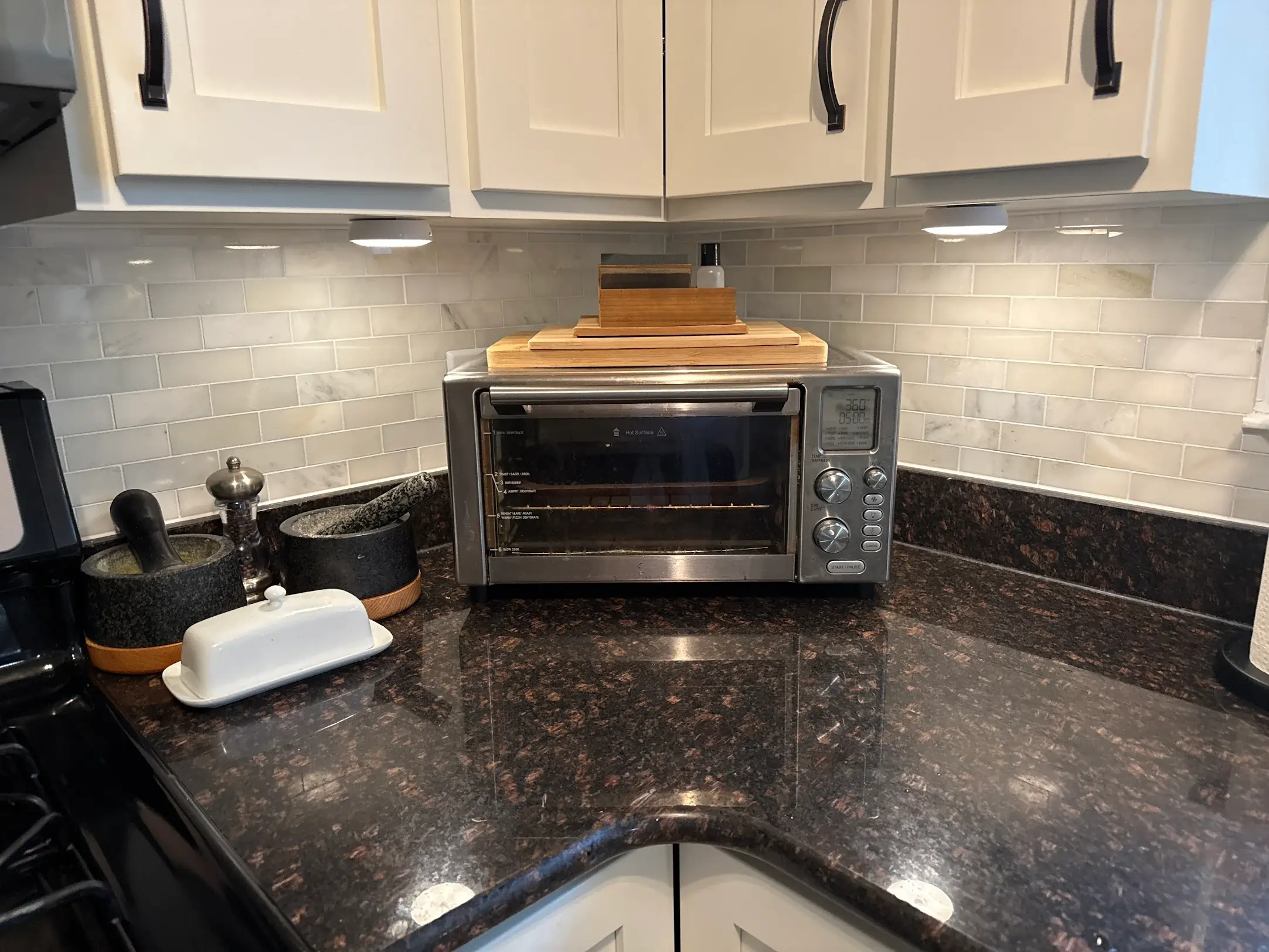Modern kitchen with countertop oven and lights under cabinets